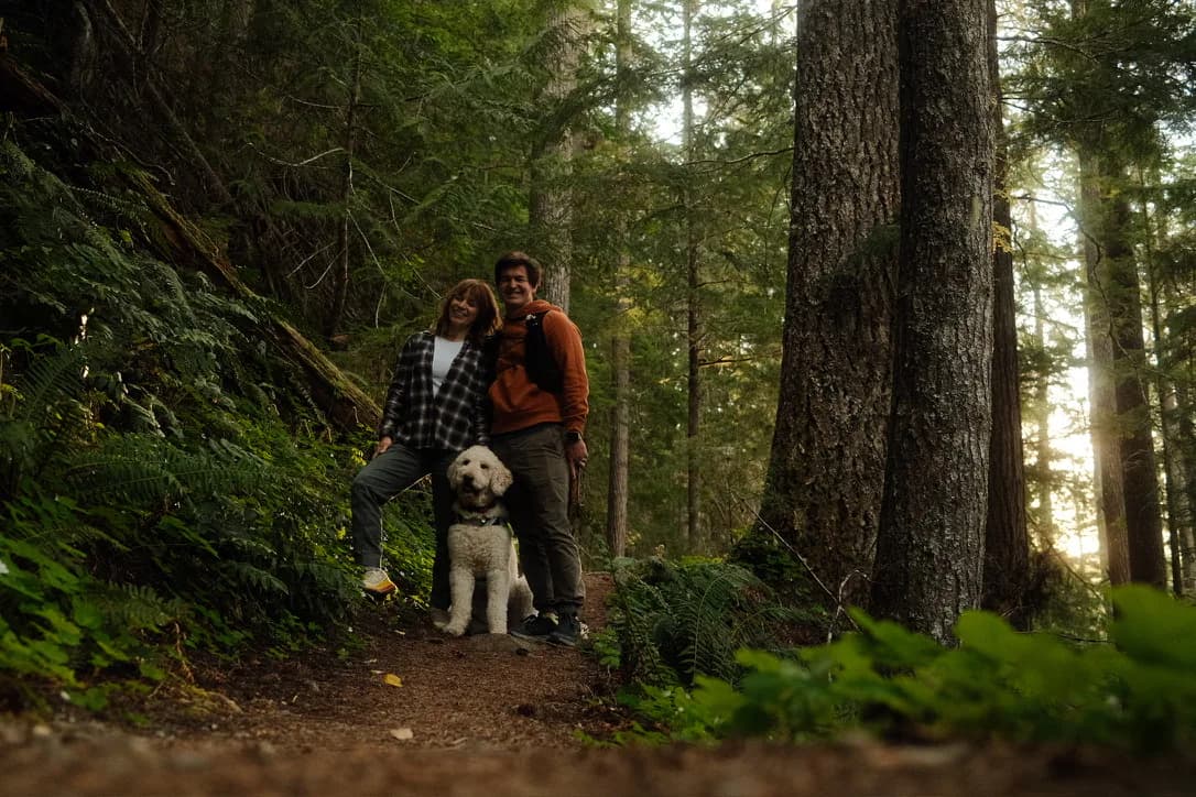 Daniel, a companion, and a dog on a forest trail