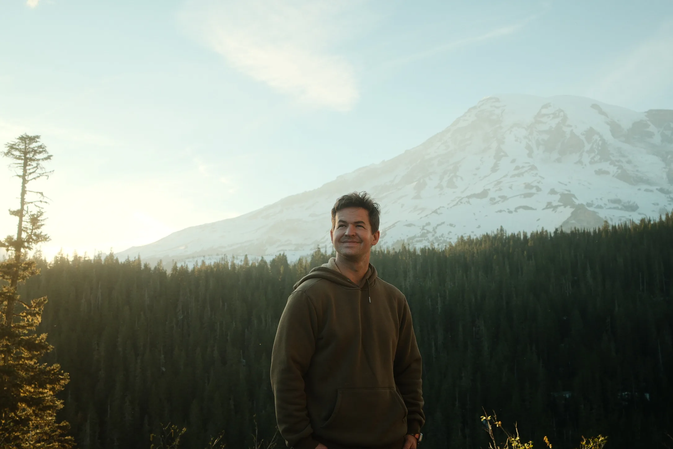 Daniel standing in front of a snow-covered mountain at sunset